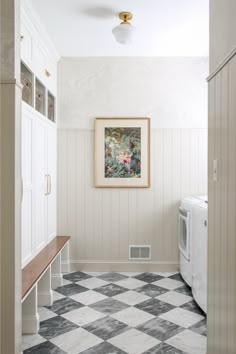 a white washer and dryer sitting next to each other in a room with checkered flooring