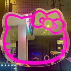 a hello kitty mirror is lit up with pink lights and an image of a cat's head