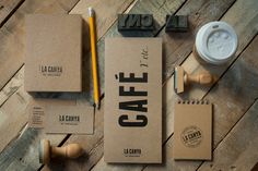 the contents of a coffee box, notepad and pen are laid out on a wooden table