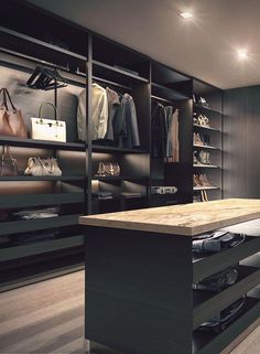 a walk in closet with lots of shoes and handbags on the shelves next to it