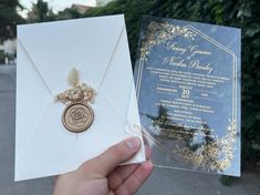 a person holding up a wedding card and envelope