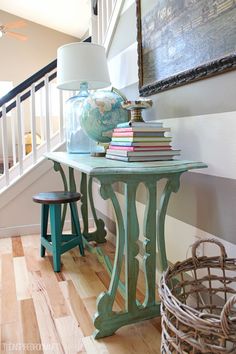 there is a table with books on it and a lamp next to the end table