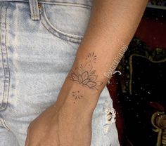 a woman's arm with a tattoo on her left wrist and a flower in the middle