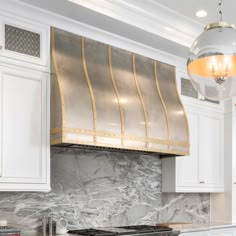 a stove top oven sitting inside of a kitchen next to white cabinets and counter tops