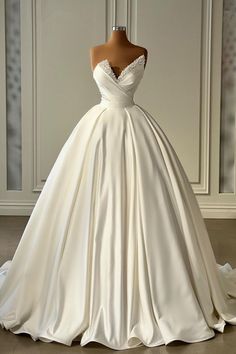 a wedding dress on display in front of a white wall with an open back and straps