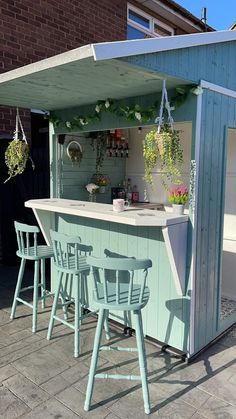 an outdoor bar with four chairs around it