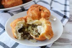 two pastries on a white plate with a blue and black checkered tablecloth