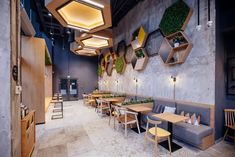 the interior of a restaurant with wooden tables and chairs, potted plants on the wall