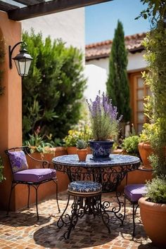 an outdoor table with purple chairs and potted plants