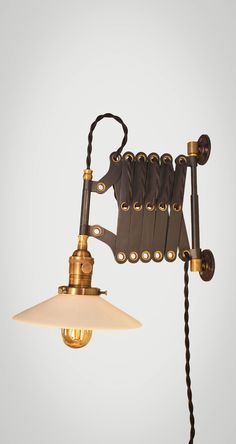 an old fashioned wall light with two lights attached to the arm and one bulb on each side