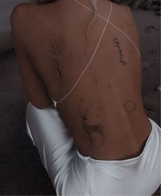 the back of a woman's body with tattoos on it