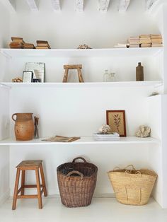 the shelves are filled with books, baskets and other items in white painted room space