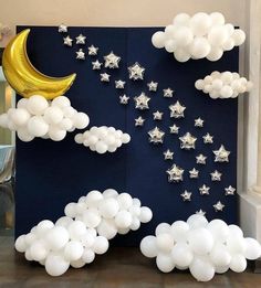 balloons are floating in the air next to a wall with stars and moon on it