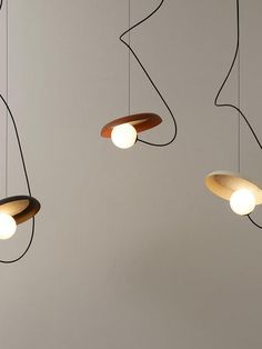 three wooden lights hanging from the ceiling in a room with white walls and flooring