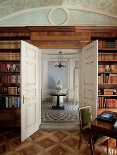 an open door leading to a room with bookshelves and a table in it