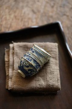 four blue and white cups sitting on top of a napkin