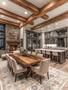 a dining room table surrounded by chairs in front of a fireplace