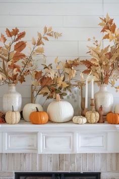 a mantle with pumpkins, leaves and candles on it