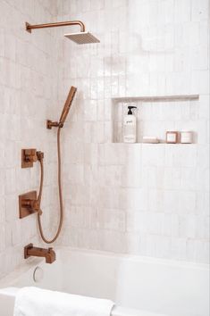 a bath tub with a shower head and hand held faucet