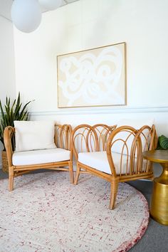 a living room with two chairs and a round rug on the floor in front of a painting