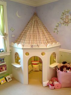 a child's bedroom with a castle bed and toys on the floor in front of it