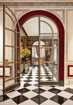 an open door leading into a room with black and white checkered floors