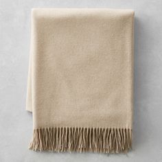 a beige blanket with fringes on it