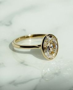 a yellow diamond ring sitting on top of a marble counter