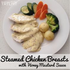 steamed chicken breast with honey mustard sauce on a white plate next to vegetables and broccoli