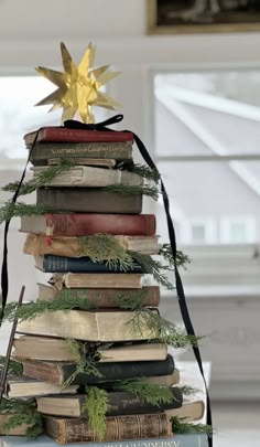 a christmas tree made out of books with a star on top