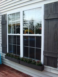 a house with two large windows and shutters