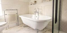 a white bath tub sitting next to a toilet in a bathroom