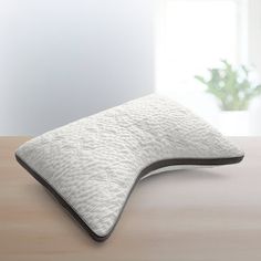 a white pillow sitting on top of a wooden table