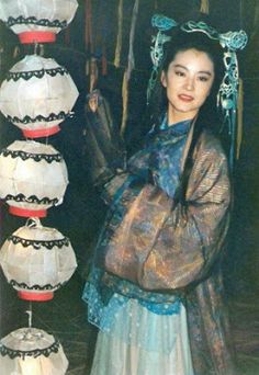 a woman standing in front of some paper lanterns