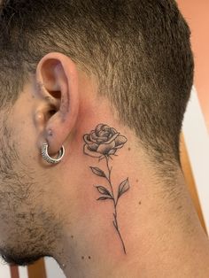 a man with a tattoo on his neck and behind the ear is a single rose