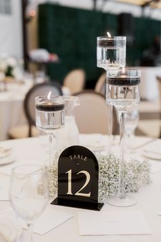 the table is set with two tall wine glasses and place cards for guests to use