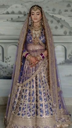 a woman in a blue and gold bridal gown with her hands on her hips