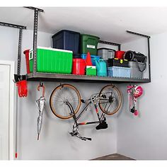 there is a bike hanging on the wall in this garage storage area with tools and other items