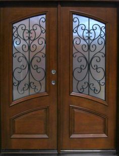 a double door with glass and wrought iron design