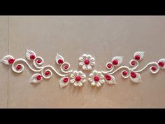 a white and red wall hanging with flowers on it