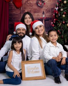 a family posing for a christmas photo in front of a tree