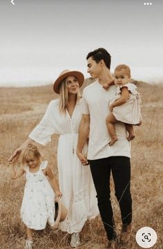 a man, woman and child standing in a field