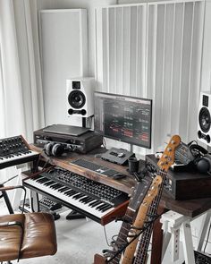 there are many musical instruments and keyboards in this room, including an electric keyboard with multiple knobs on it