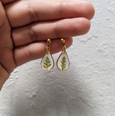 Fern earrings. Pressed flower dangle earrings. Tiny leaf studs. Small fern earrings. Green leaf jewelry. Small nature jewelry. Dainty resin earrings. Real fern leaf plant jewelry. Gift for gardener. Gift for plant lover. These tiny teardrop dangle earrings are handmade and feature real fern leaves encased in resin. Available in gold or silver and featuring a ball stud. Other variations are available in: Large (gold), Medium (gold or silver). Minimalist and earthy, great for boho bridesmaids in y Nature-inspired Drop Earrings With Natural Inclusions, Leaf-shaped Jewelry With Matching Earrings, Leaf-shaped Jewelry With Matching Earrings For Gift, Minimalist Leaf-shaped Jewelry With Matching Earrings, Nature-inspired Teardrop Earrings For Gifts, Handmade Leaf-shaped Botanical Earrings, Handmade Botanical Leaf Earrings, Green Botanical Drop Earrings Jewelry, Nature-inspired Hypoallergenic Flower Dangle Earrings