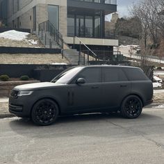 a black range rover parked in front of a building with stairs leading up to it