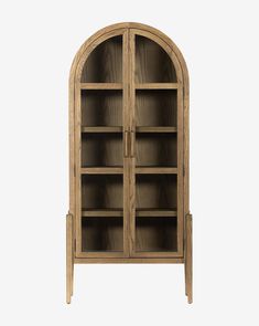 an arched wooden bookcase with glass doors