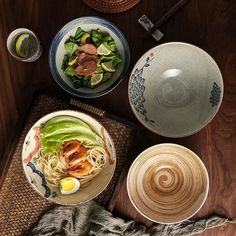 a table topped with plates and bowls filled with food next to chopsticks on top of a cutting board