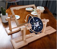 a wooden table topped with two coasters and a clock on it's stand