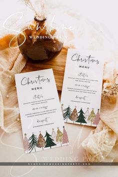 two christmas menus sitting on top of a table