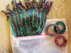 several bracelets and rings sitting on top of a white bag